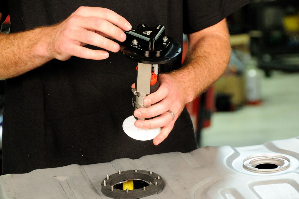 man installing a fuel pump into a gas tank