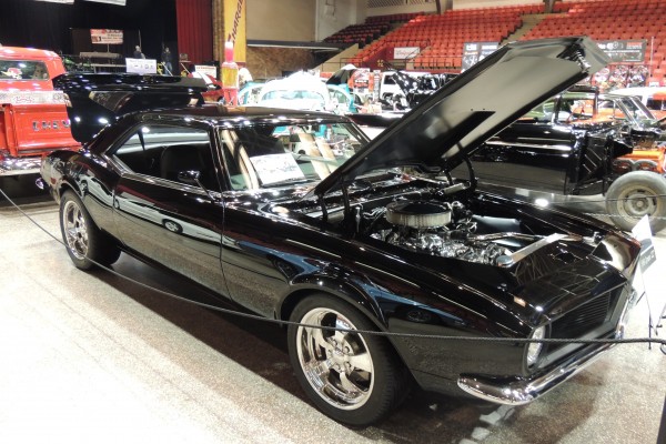 Black 1968 Chevy Camaro displayed at indoor car show