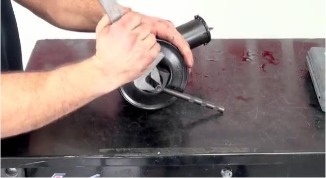 man removing a pulley from a power steering pump