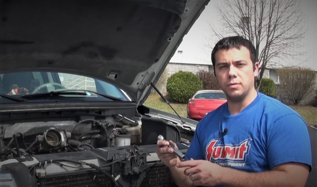 man standing in front of an f-150 truck with hood up