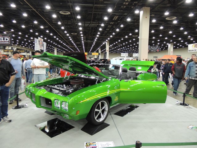 Green pontiac GTO displayed inside at a car show