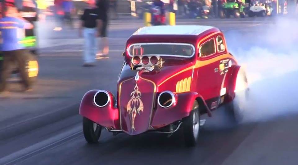 modified gasser doing a burnout at a dragstrip