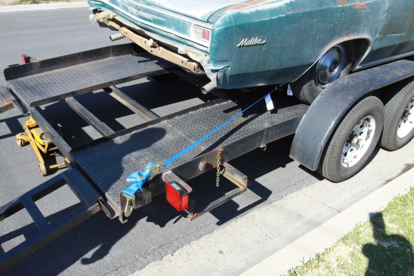 chevy malibu tied down to a car trailer