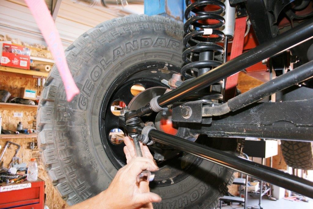 working on the front suspension of a jeep wrangler tj