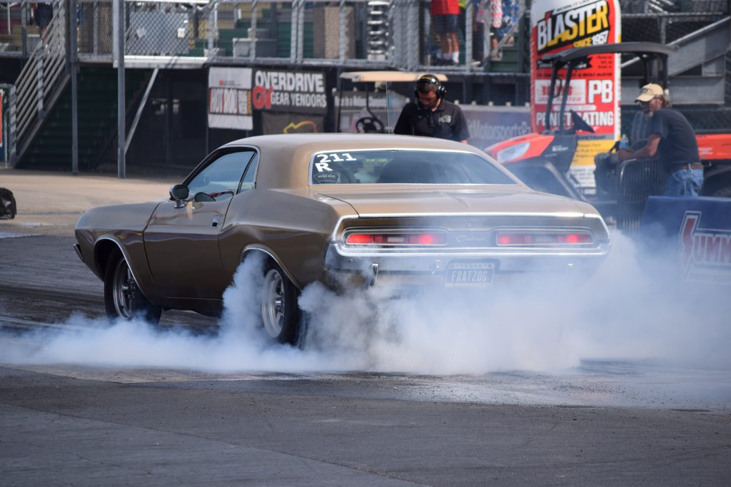 first gen dodge challenger doing a burnout at a drag strip