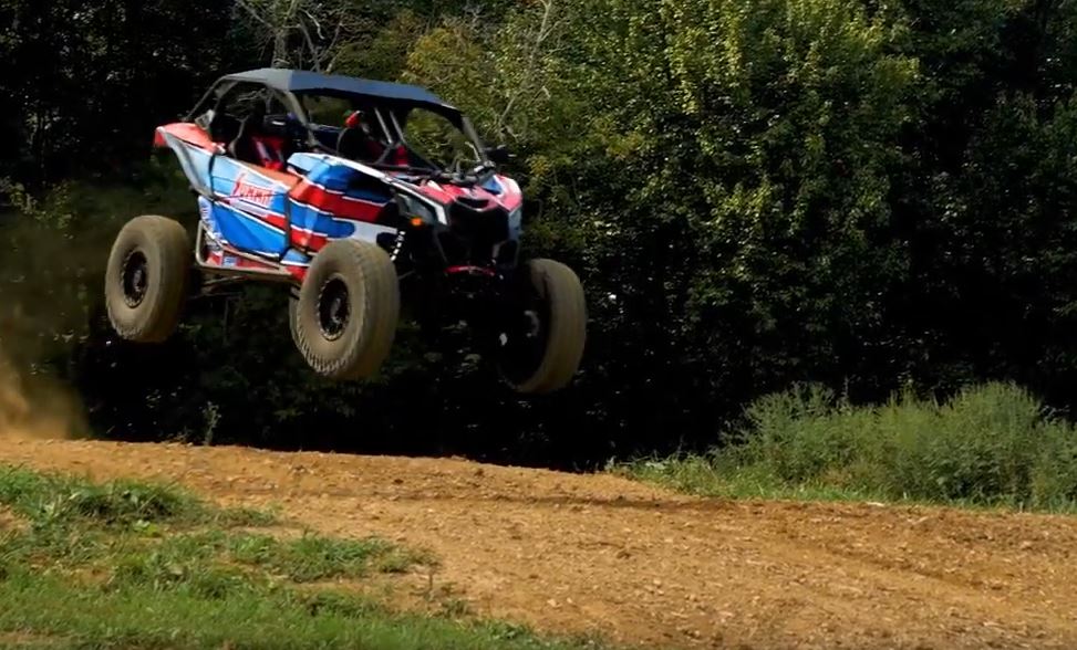 Summit Racing can am utv leaping over a dirt hill