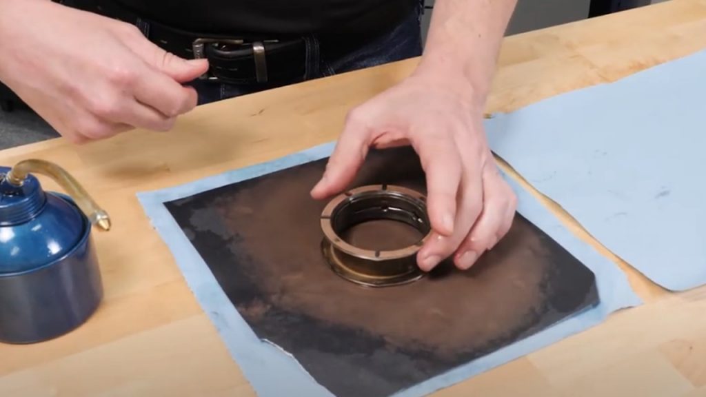 polishing and greasing a thrust bearing on a workbench