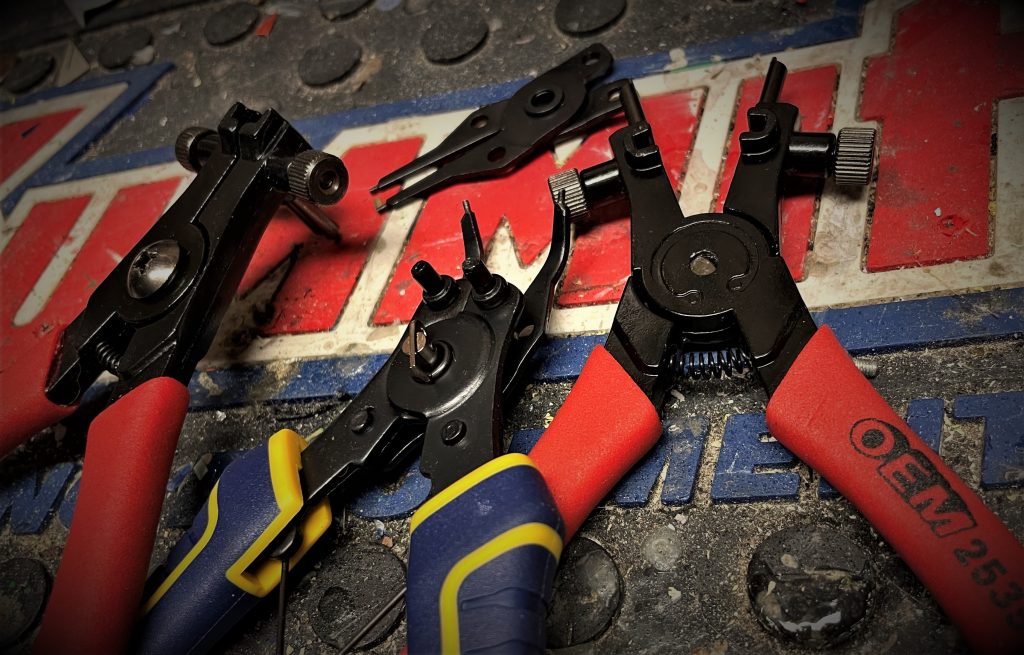 an assortment of snap ring pliers on a workbench