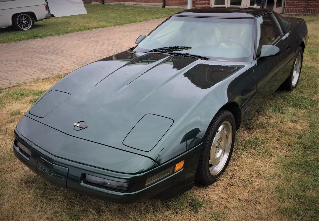 front quarter shot of a black 1994 chevy corvette c4 convertible parked on grass at a car show