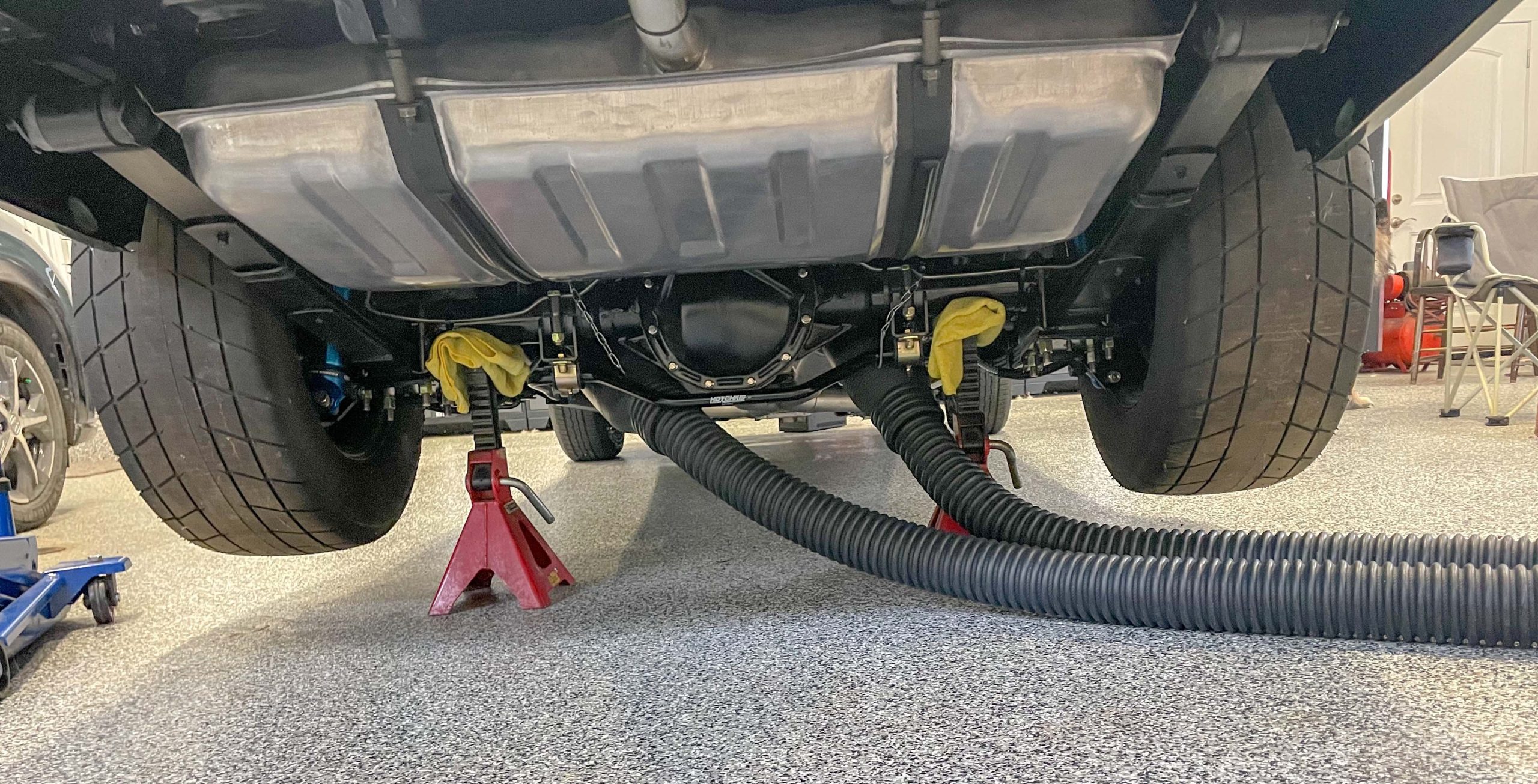 https://www.onallcylinders.com/wp-content/uploads/2023/02/08/garage-exhuast-system-installed-on-tailpipes-of-an-old-muscle-car-scaled.jpg