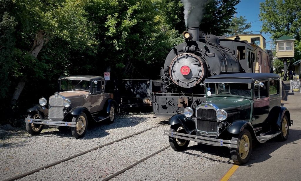 a pair of ford model a cars and a vintage steam locomotive train engine 2