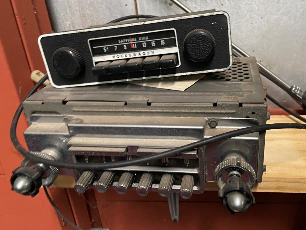 stack of vintage car stereos on a shelf