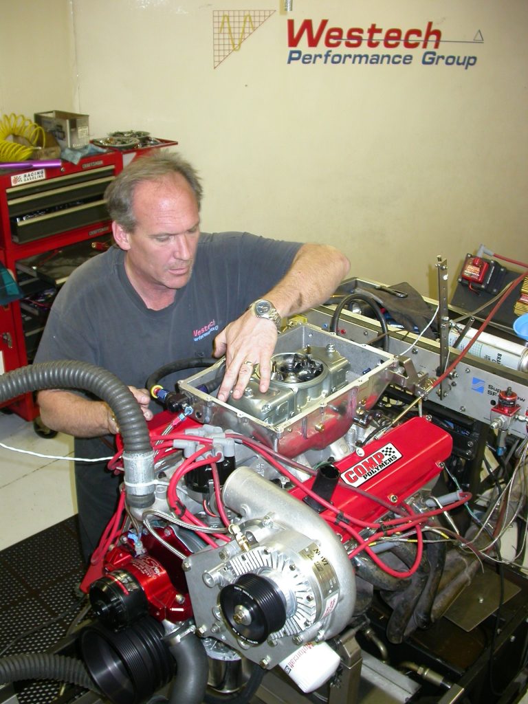 man working on an engine on a dyno