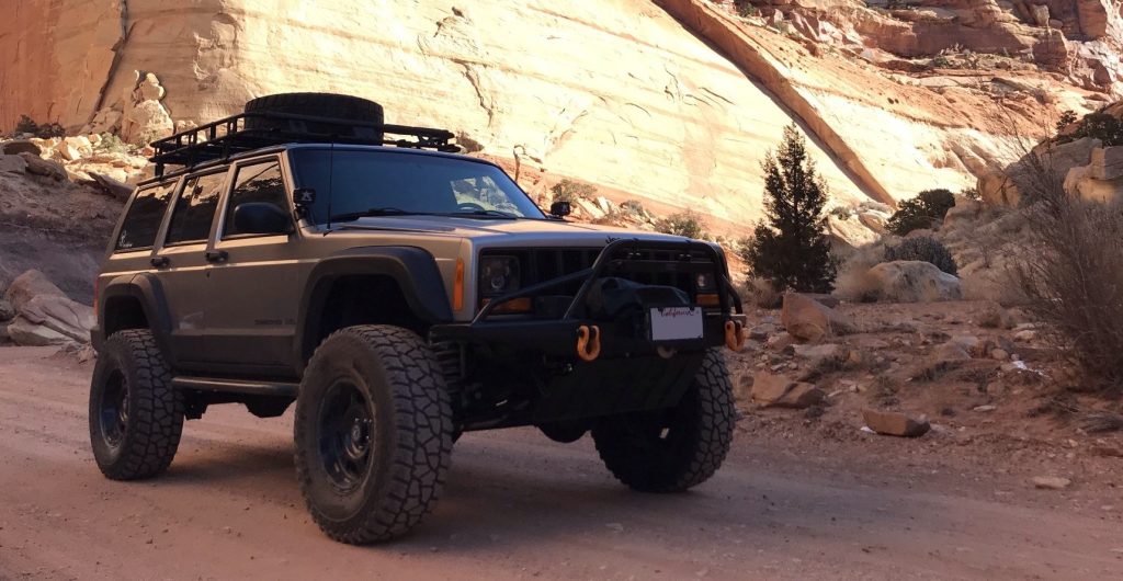jeep cherokee xj driving on a mountain desert trail