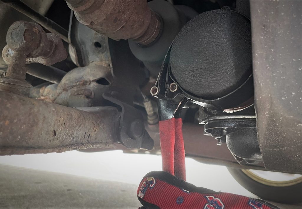 man using oil filter wrench on a Nissan QR25DE