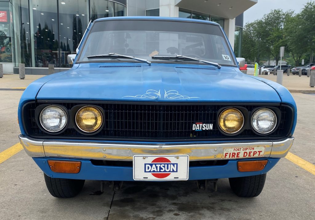 Blue 1976 Datsun Nissan 620 pickup truck, front grille