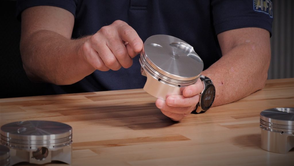 close up of piston being held near workbench