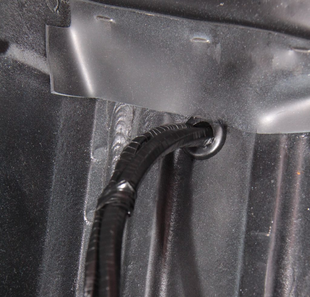 Passing wiring harness through rubber grommet