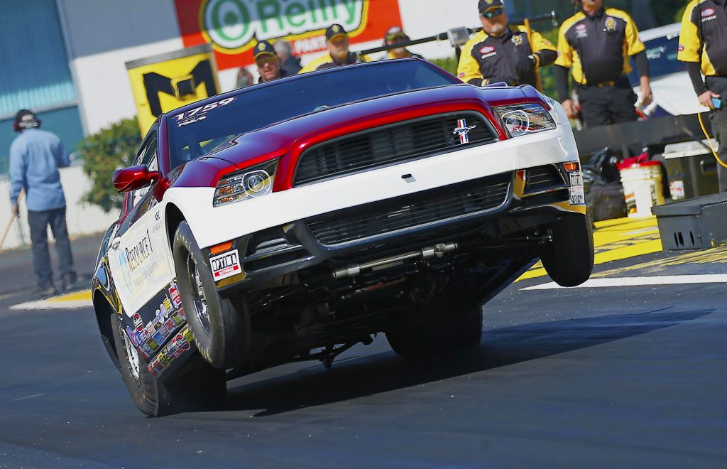 close up of ford mustang wheelstand at dragstrip