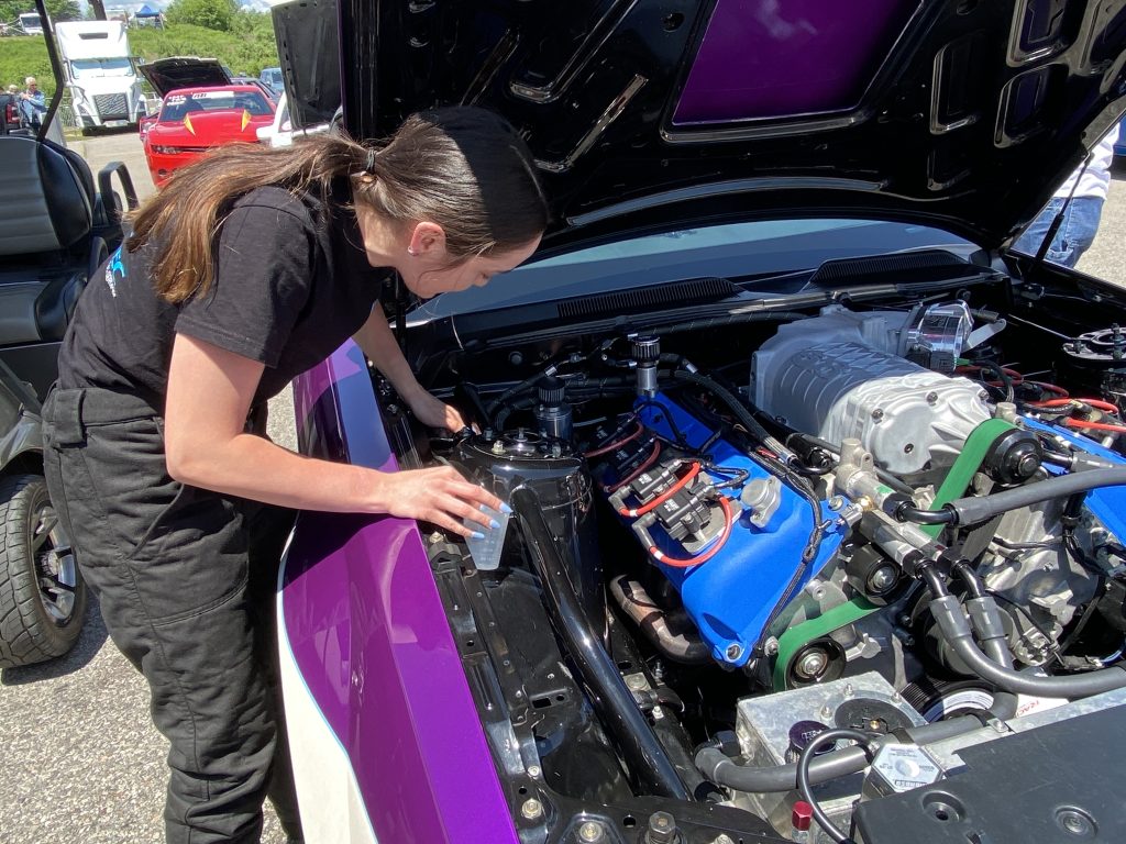 racer working under the hood of a race car