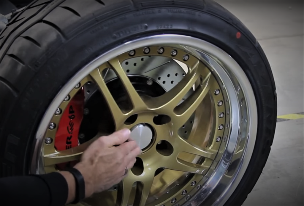 man gesturing towards center of a custom wheel