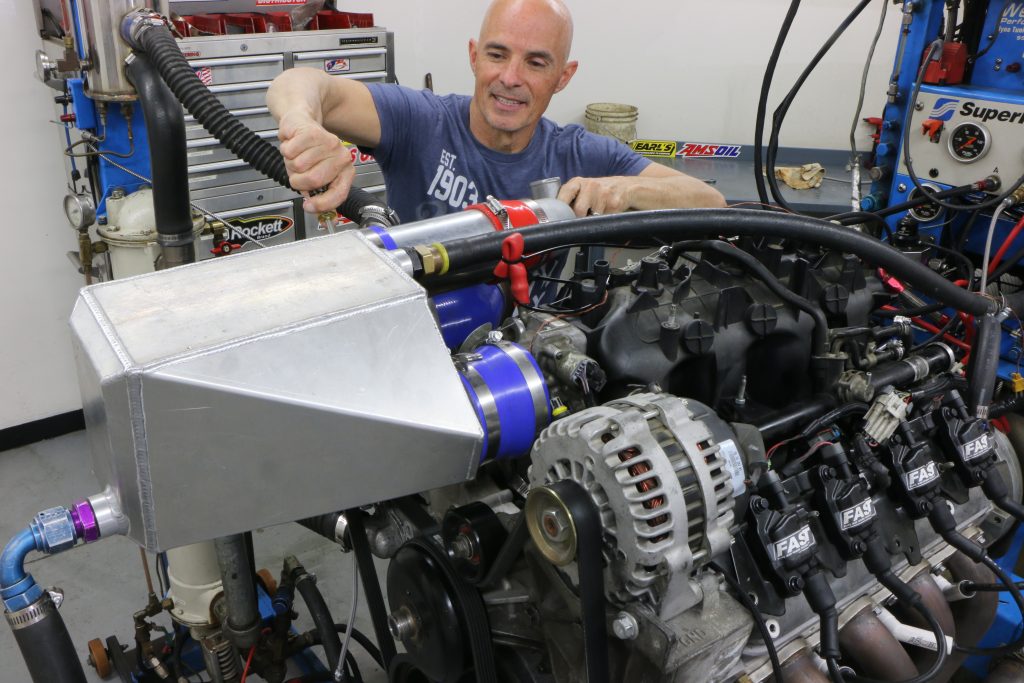 Man installing intercooler onto an engine dyno