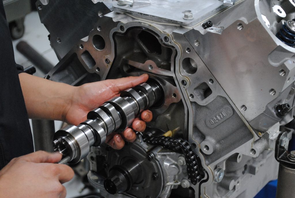 man installing camshaft into an ls engine