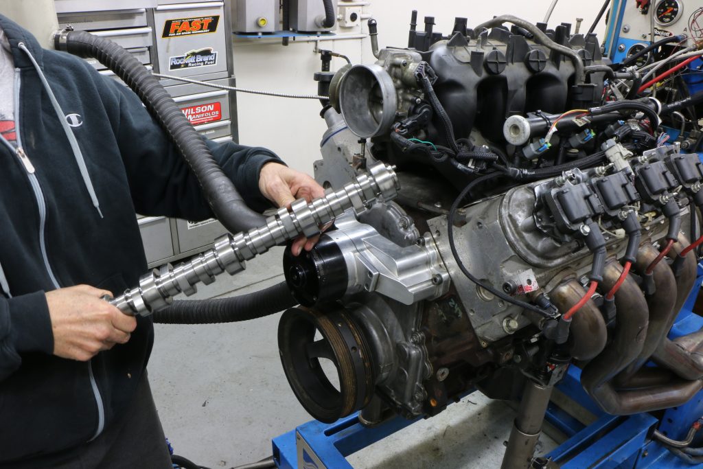 man installing a camshaft into an engine