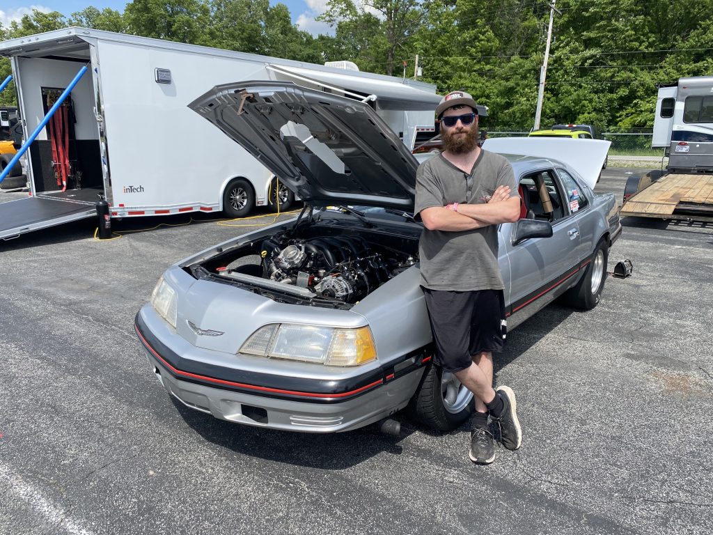 man leaning against a 1980s ford thunderbird