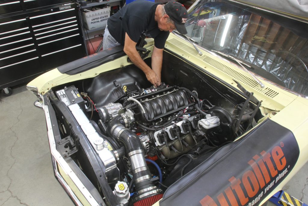 man working on an LS engine in a Chevelle