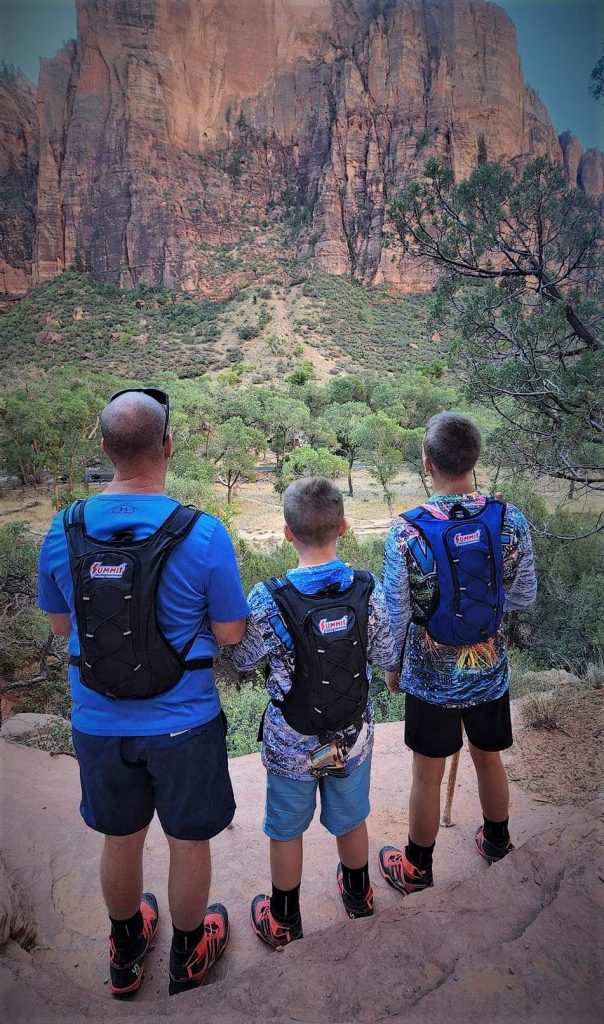 family wearing summit racing hydration packs near gorge