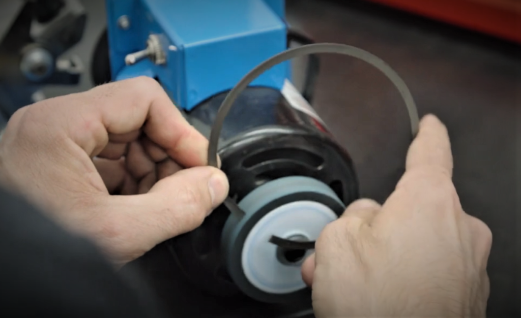 filing down a piston ring on a grinder tool