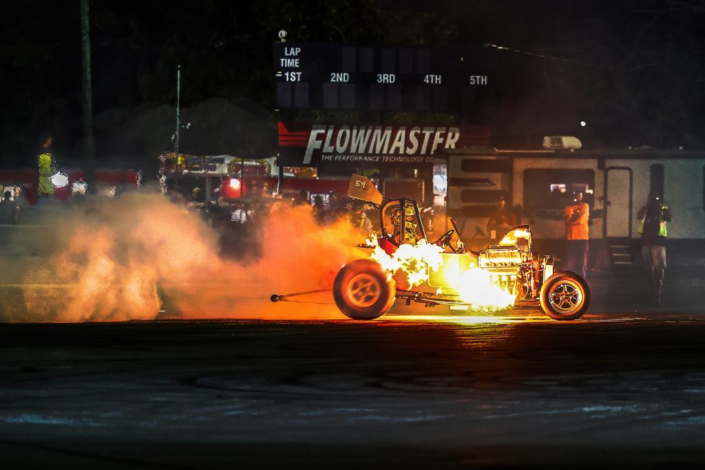 vintage ford dragster shooting flames at dragstrip