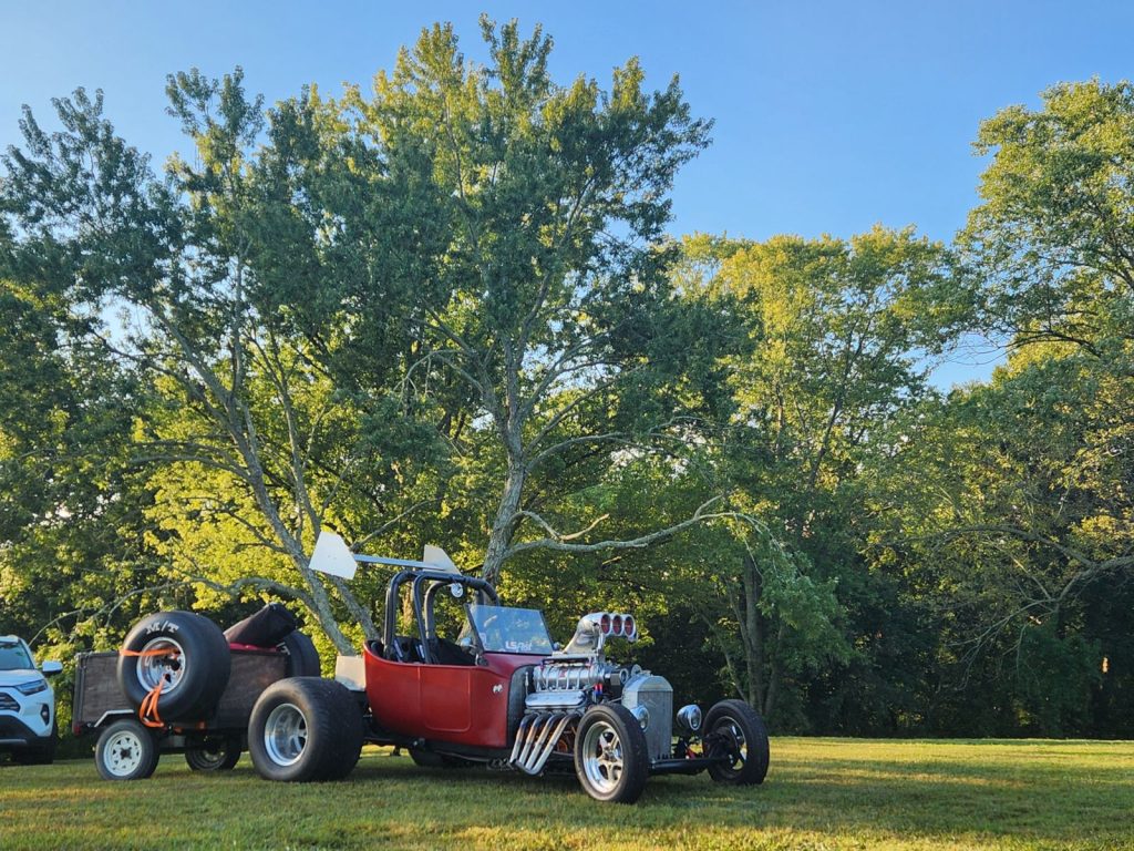 ford model t hot rod parked on grass with trailer