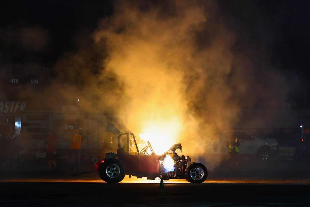 ford model t dragster at night with flames in background