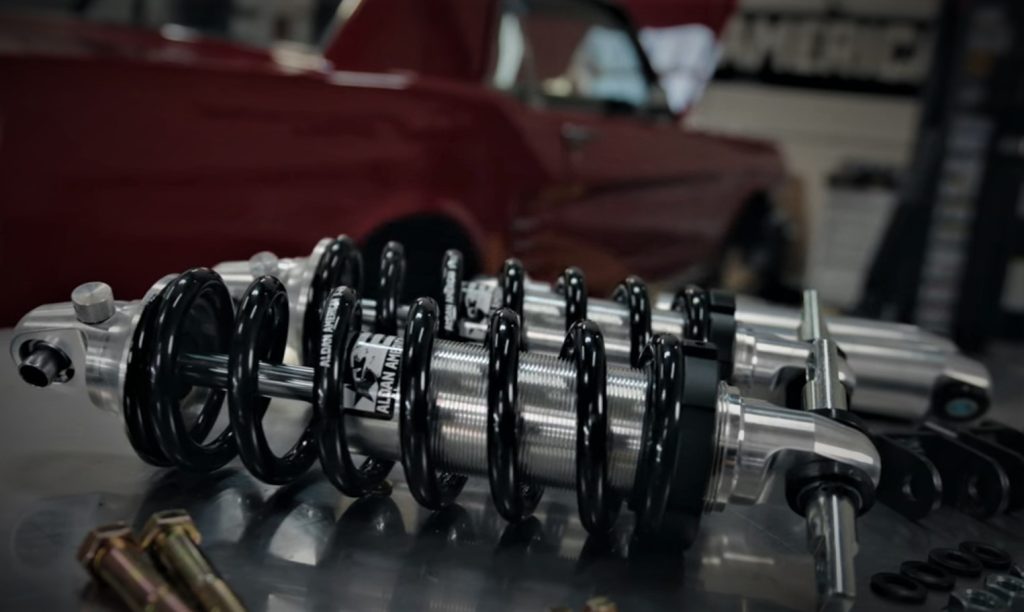 aldan american shocks on workbench near a classic mustang