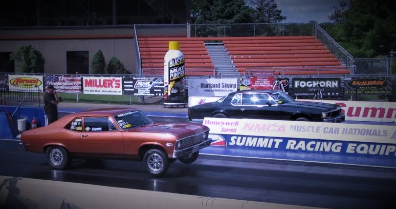 a pair of drag racers launching at a dragstrip