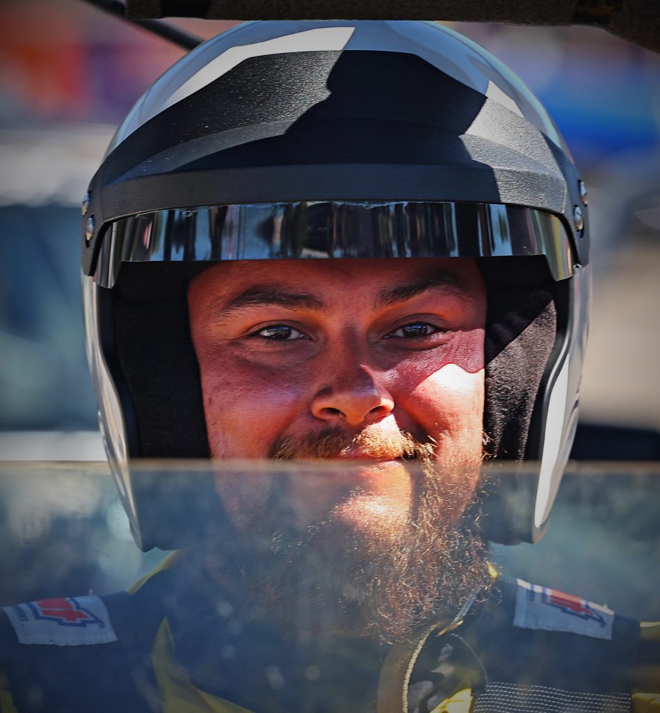 smiling race car driver in cockpit