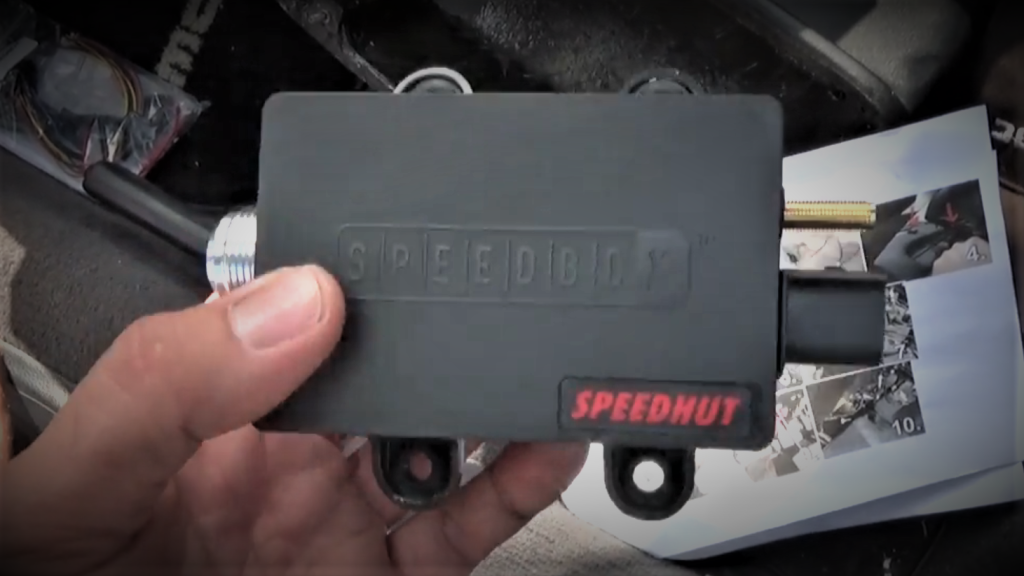 man holding a speedhut speedbox module