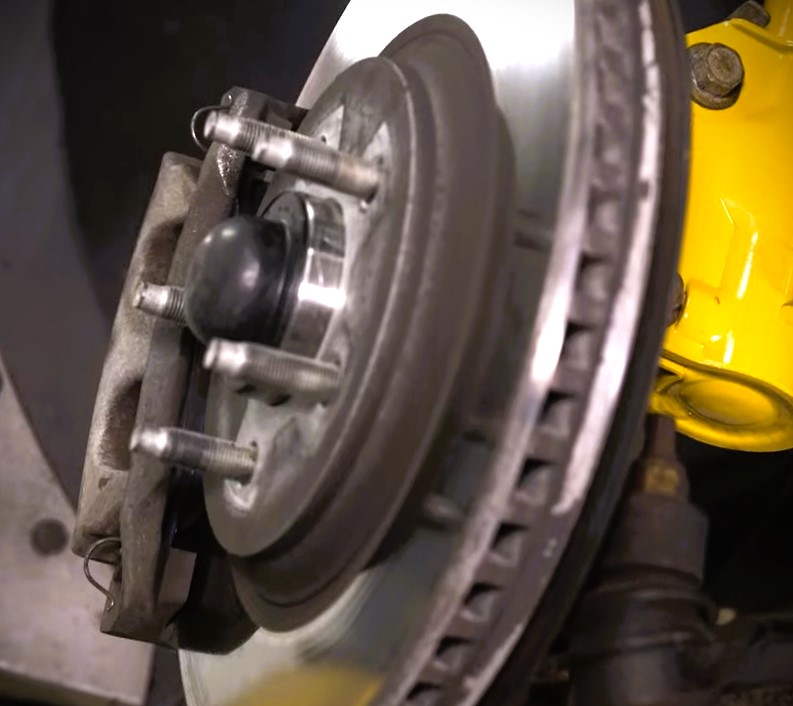 view of a solid brake rotor and caliper on a spec mustang