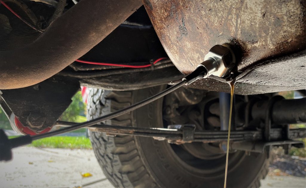 specialty tool being used to remove engine oil drain plug