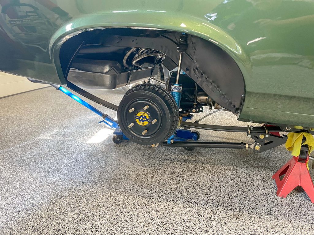 Floor jack under Chevy Nova's rear axle