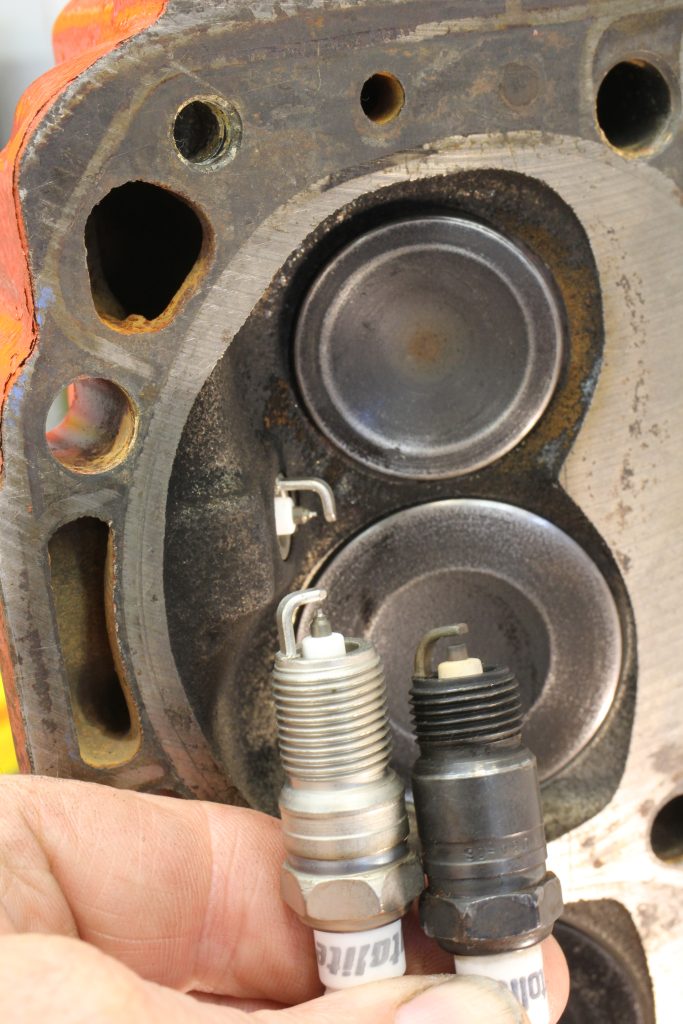 Spark plug held near a cylinder head