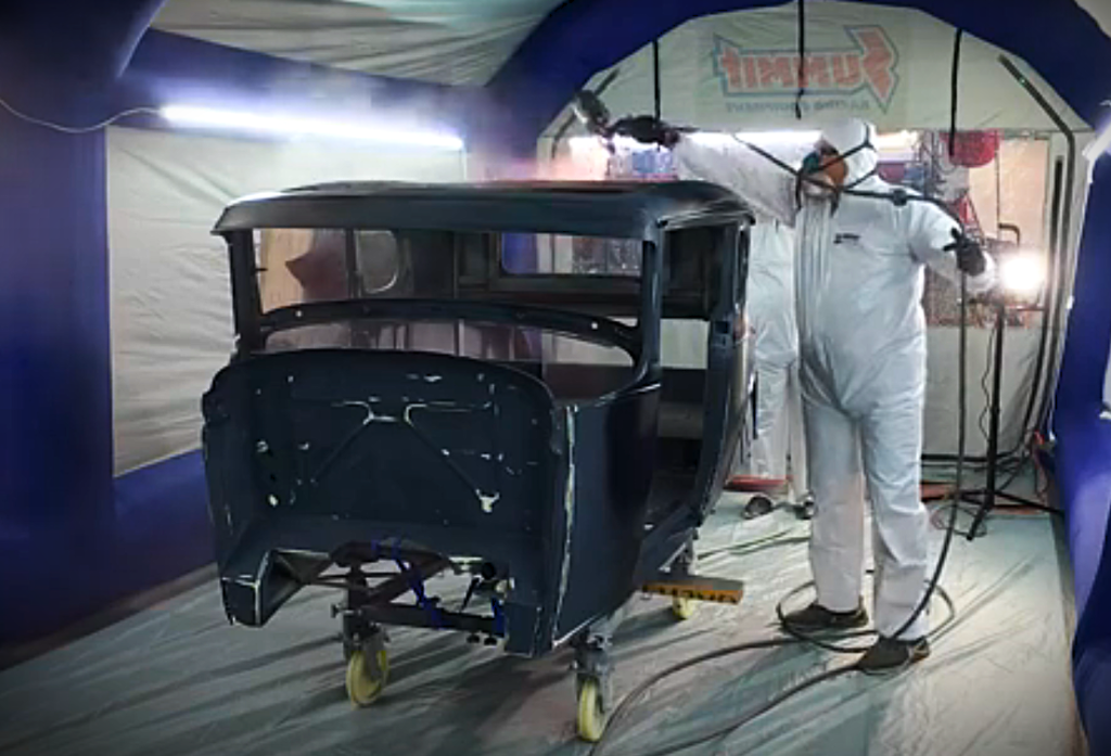 man painting in a portable paint booth