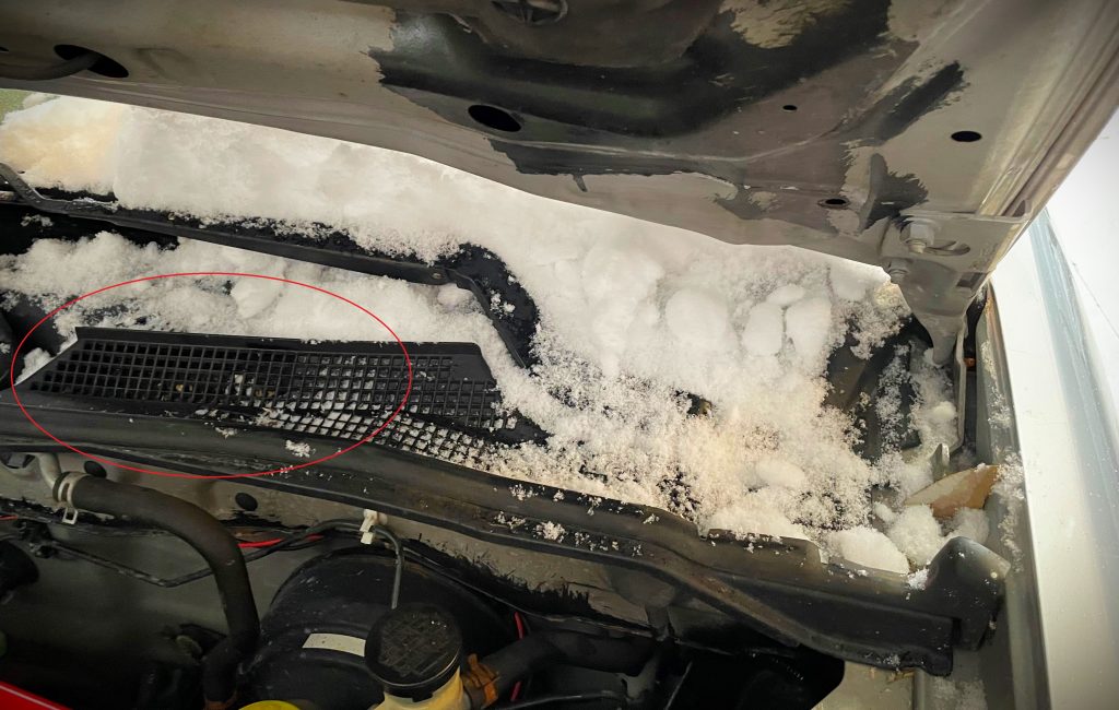 Snow Covered under hood of Nissan Sentra