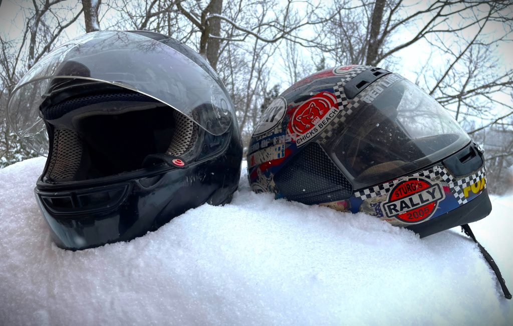 a pair of motorcycle helmets in the snow