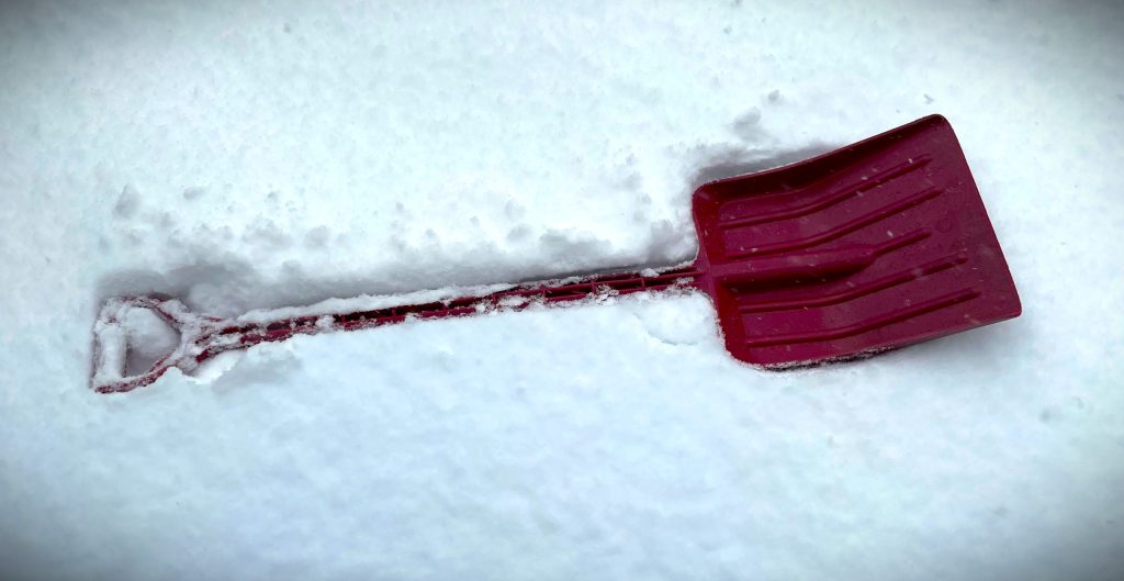 child's snow shovel resting in the snow